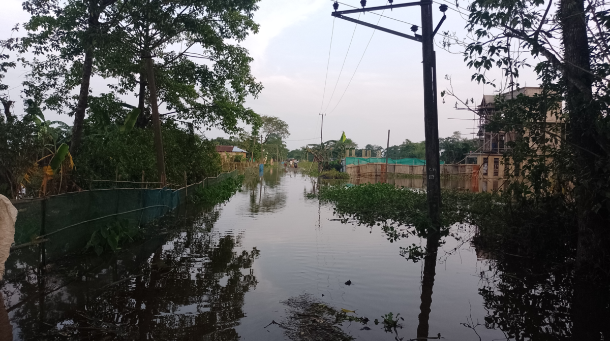 豪雨により道路が冠水し、乗用車が半分ほど水に浸かっている。